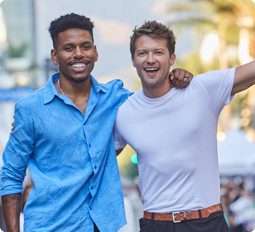 Two friends smiling together at a fan zone event
