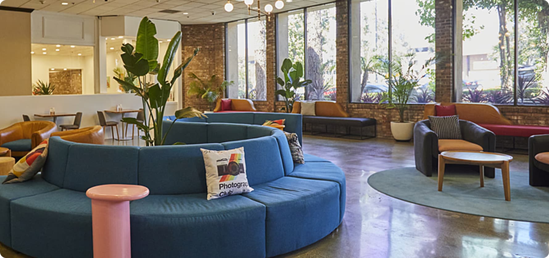 Stylish hotel lobby with modern blue curved sofa and plants